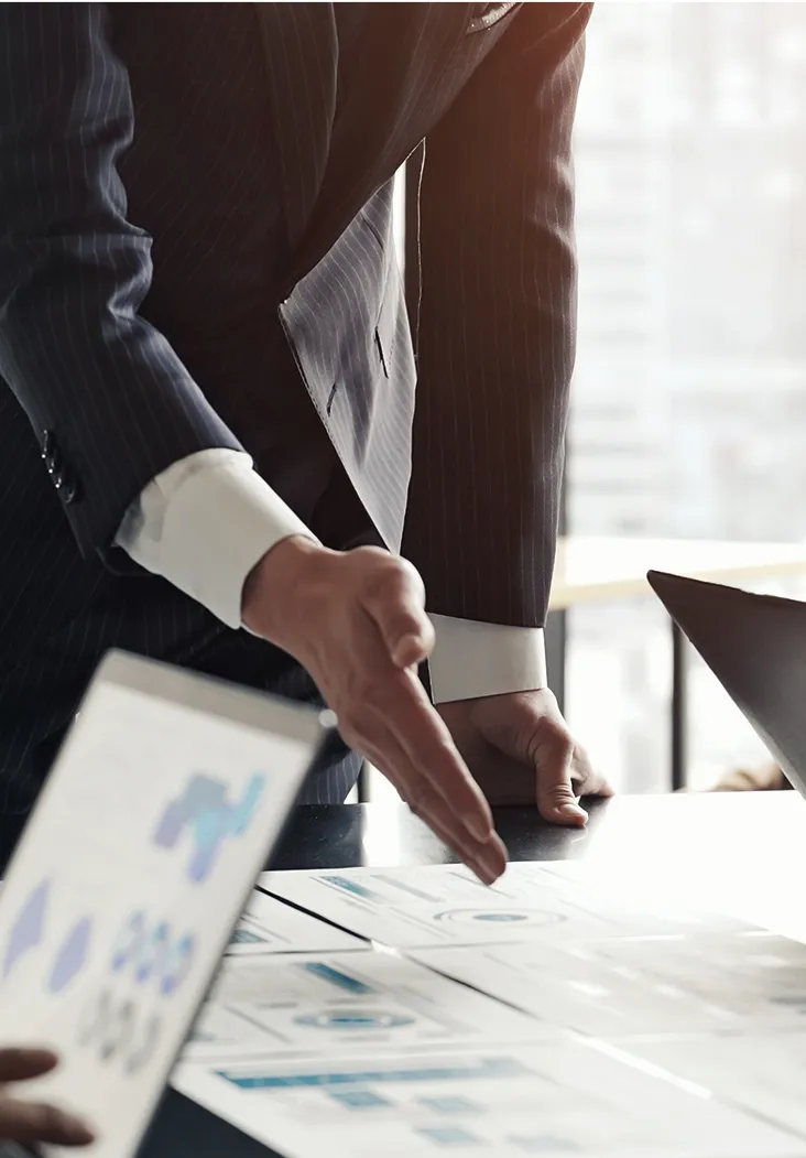 複数の社員がテーブルで資料を広げて話し合う様子